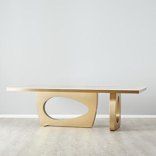 Modern rectangular dining table seating up to 8 people, featuring a white sintered stone tabletop. Supported by two gold stainless steel frames with egg holes.